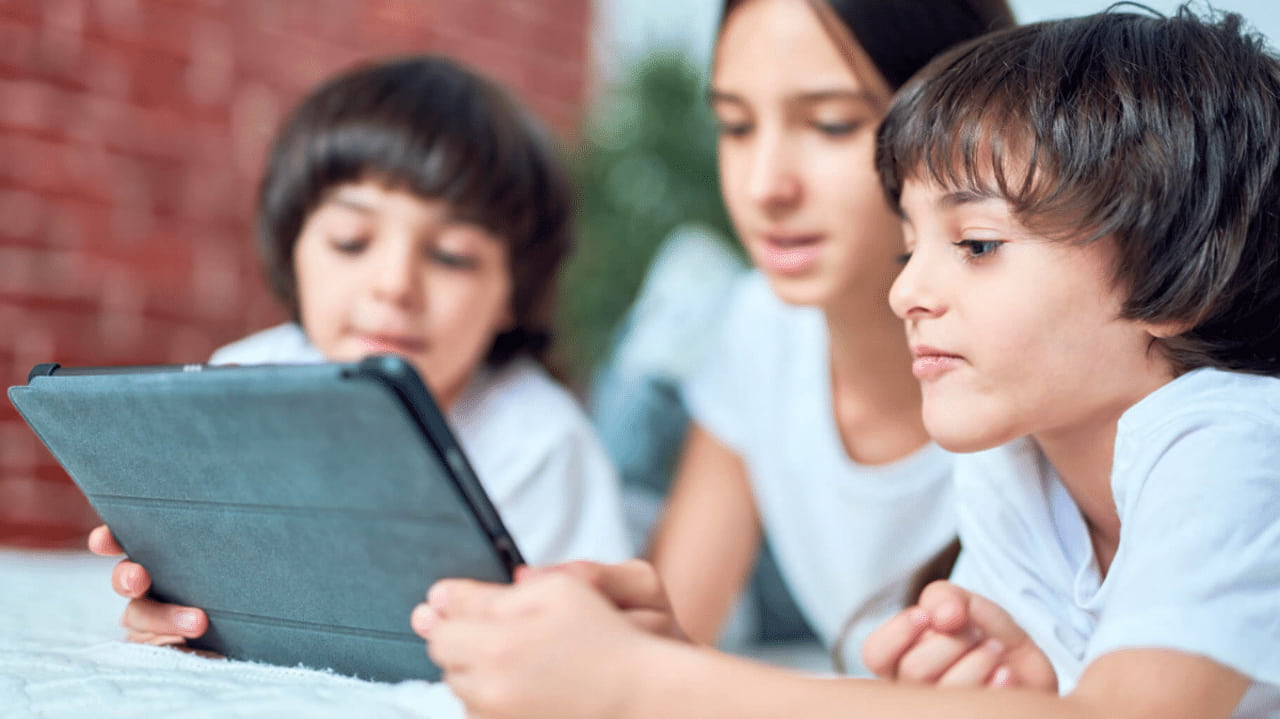 Un gruppo di bambini con tablet naviga su siti e servizi online sicuri grazie a SPID minori.